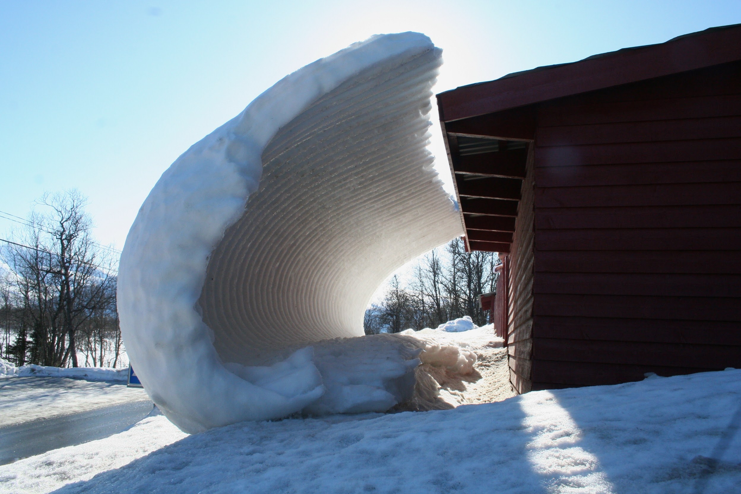 Sneeuw valt van schuur in Tromsø
